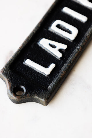 Detail shot of the Ladies Door Hanging Sign displayed on a white marble surface.