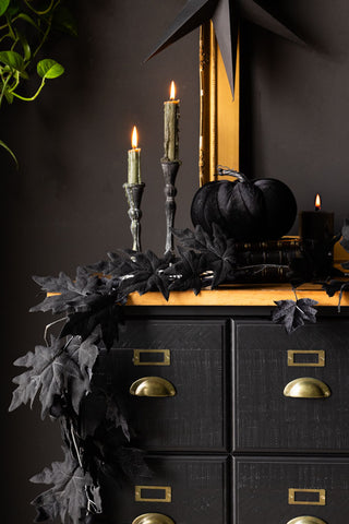 The Large Black Velvet Pumpkin displayed on cabinet with maple leaf garland, candles and gold frame.