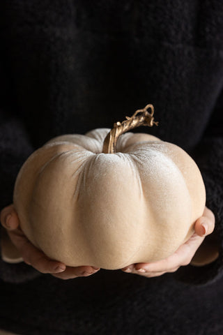 The Large Cream Velvet Pumpkin being held in a model's hands.