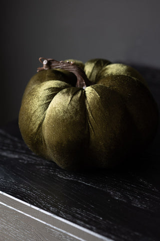 The Large Green Velvet Pumpkin styled on a dark wooden surface.