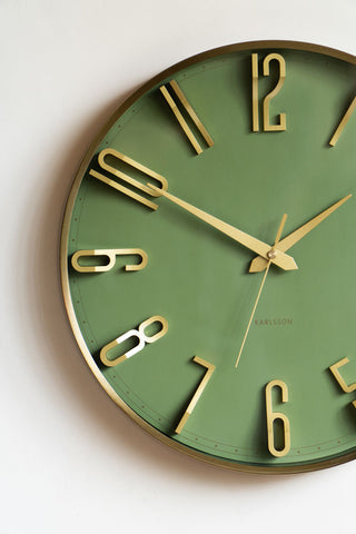 The Large Green & Gold Wall Clock displayed on a white wall.