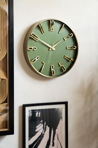 The Large Green & Gold Wall Clock on a wall with some framed artworks.