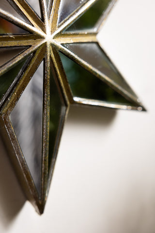 Close-up of the Large Mirrored Star Wall Decoration on a white wall.