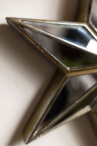 Detail shot of the Large Mirrored Star Wall Decoration on a white wall.