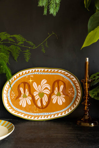 Image of the Large Oval Plate With Hearts styled on a black surface with green plants.