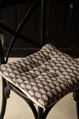 The Leaf Print Seat Cushion styled on a dining chair.