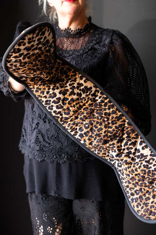 The Luxury Leopard Print Oven Gloves being modelled in front of a dark background.