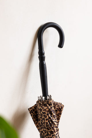 The curved handle of the leopard print umbrella.