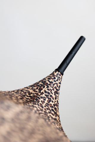 The pointed top of the curved handle umbrella.