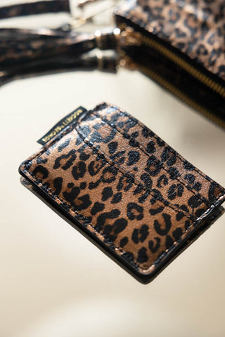 The Leopard Print Card Holder displayed on a surface with a leopard print bag.