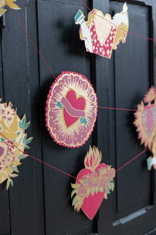 The Love Hearts Paper Garland draped across the front of a black sideboard.