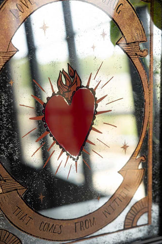 Close-up of the heart detail on the Love Is The Drug Decorative Mirror.