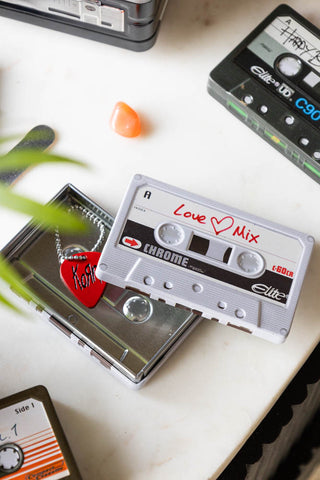 The Love Mix Cassette Tape Storage Tin on a white surface with various other tins and accessories.