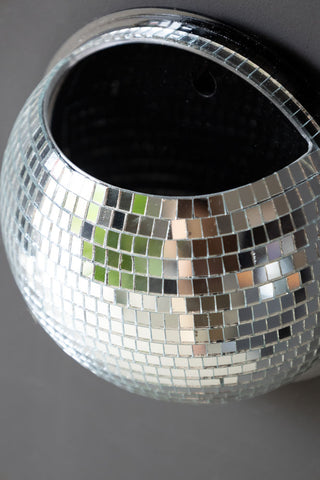 Silver disco mirror ball holder with flat magnetic back styled against dark grey wall