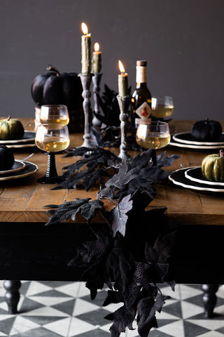 The Maple Leaf Garland styled on a wooden table as part of a Halloween themed tablescape.