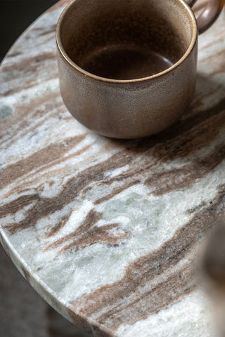 Close-up of the top of the White Marble Round Side Table, styled with a mug on.