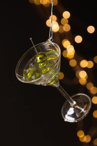 The Martini Glass Christmas Tree Decoration hanging in front of a dark background with fairy lights.