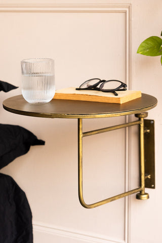 The Metal Table & Wall Shelf in use as a bedside table, styled with a plant, water glass, book and pair of glasses.