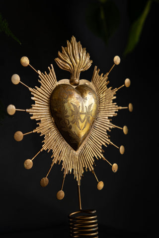 Close-up of the Milagro Heart Christmas Tree Topper in front of a dark background.