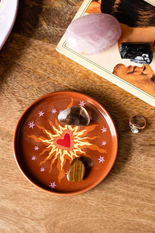 Image of the Milagro Heart On Fire Small Side Plate styled with crystals on a wooden counter-top.