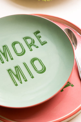 Detail shot of the Mint Green Amore Mio Plate styled on a pink plate with a spoon.