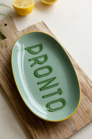 The Mint Green Pronto Plate styled on a wooden chopping board next to some lemons.