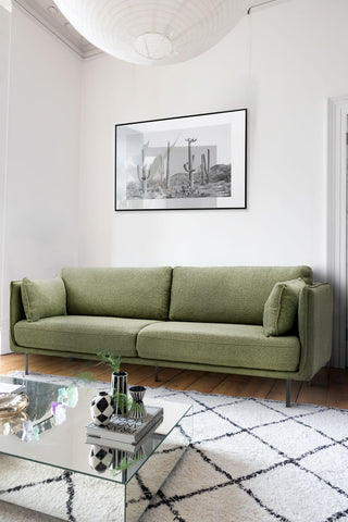 The Modern Green Boucle 3-Seater Sofa styled in a living room with a rug, coffee table, art print and various home accessories.