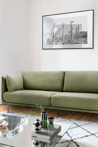 Close-up of the Modern Green Boucle 3-Seater Sofa styled in a living room with an art print, rug, coffee table and various accessories.