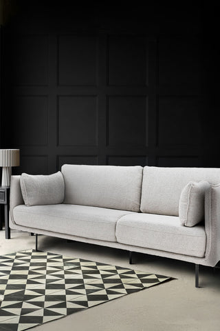 The Modern Natural Boucle 3-Seater Sofa styled in a living room with a monochrome rug, side table and a table lamp.