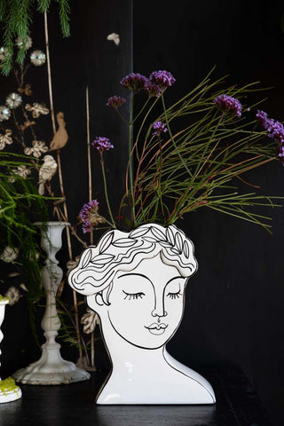 The Peaceful Monochrome Lady Vase styled on a sideboard with flower inside.