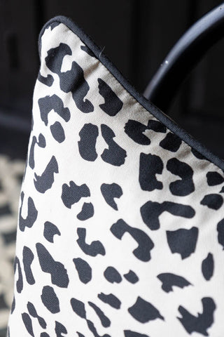 Close-up of the corner of the Monochrome Leopard Sit The Fuck Down Cushion.