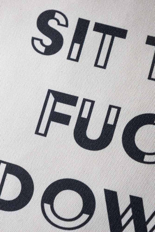 Close-up of the text on the Monochrome Leopard Sit The Fuck Down Cushion.