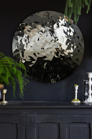 The Mosaic Disc Wall Art styled on a wall above a black sideboard, styled with candlestick holders and greenery.