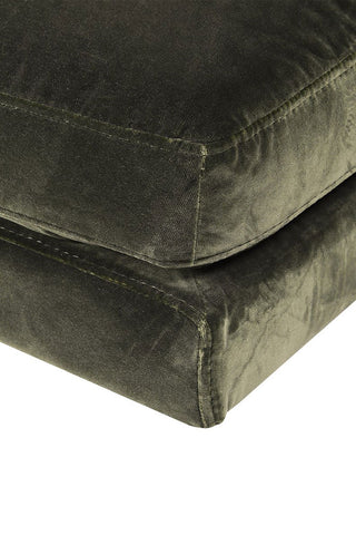 A detailed look at the dark green velvet fabric of the chaise chair.