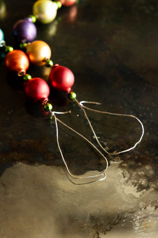 Close-up of the hanging loops on the Multi-Colour Bauble Garland, displayed on a dark surface.