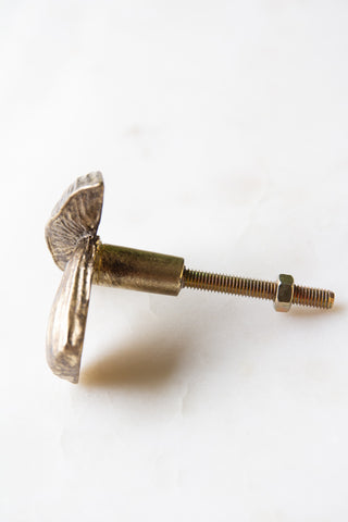 The Mushroom Knob - Gold on its side, displayed on a white surface.