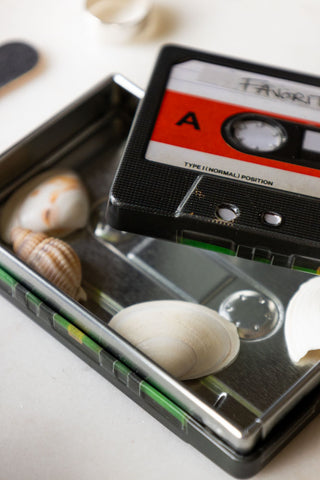 Detail shot of the My Favourite Tunes Cassette Tape Storage Tin with the lid off, styled with various shells inside.