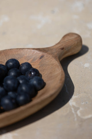 Close-up of the Natural Wood Carved Serving Dish with blueberries inside.