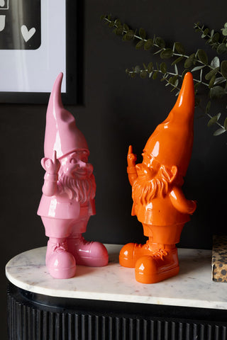 The Fabulous Pink Naughty Gnome and the orange version styled together with a plant.