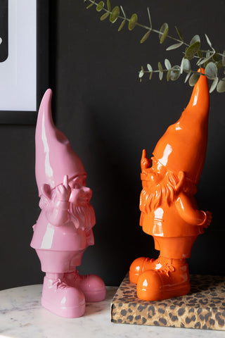 The Fabulous Pink Naughty Gnome with the orange version styled on a sideboard.