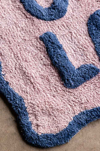 Close-up of one corner of the Navy & Pale Pink C'est La Vie Bath Mat.