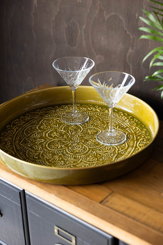 The Olive Green Floral Detail Serving Tray styled on a sideboard with two cocktail glasses.