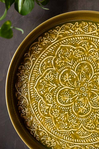 Close-up of the Olive Green Floral Detail Serving Tray leaning against the wall.