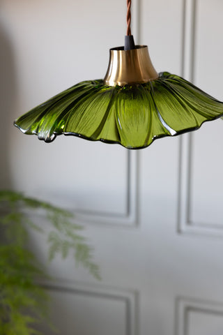 Close-up of the Olive Green Flower Glass Easyfit Ceiling Light Shade with a plant in the background.