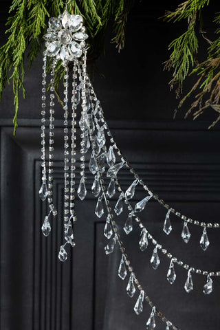 Close-up of one end of the Opulent Crystal Decoration, displayed hanging from a fireplace with some greenery.