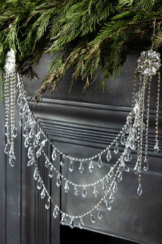 The Opulent Crystal Decoration displayed hanging from a fireplace with some greenery.