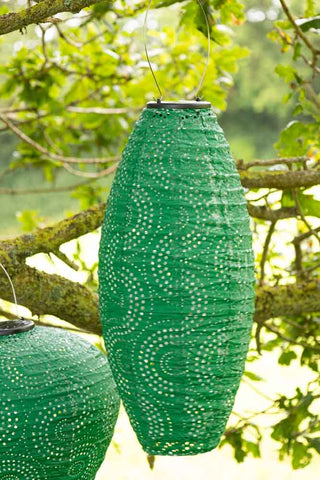 The Oval Shaped Green Outdoor Garden Lantern shown hanging in the trees.