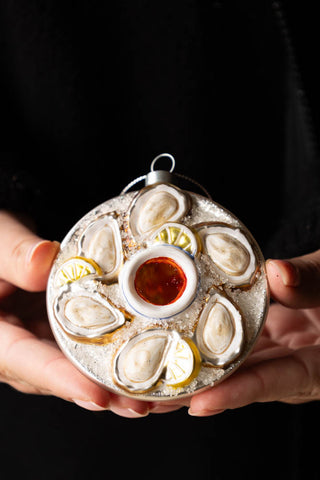 The Oyster Christmas Tree Decoration being held in a model's hands.