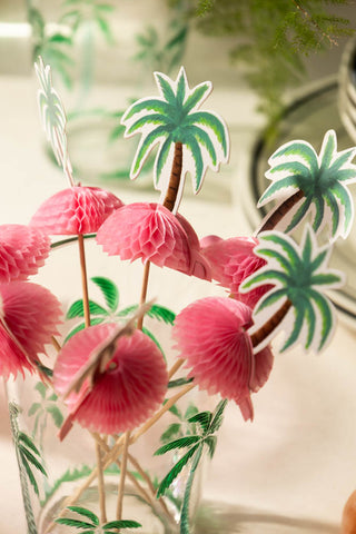 Several of the Palm Tree Party Toothpicks styled in an empty glass.