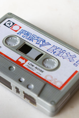 Close-up of the Party Mix Cassette Tape Storage Tin on a white surface.